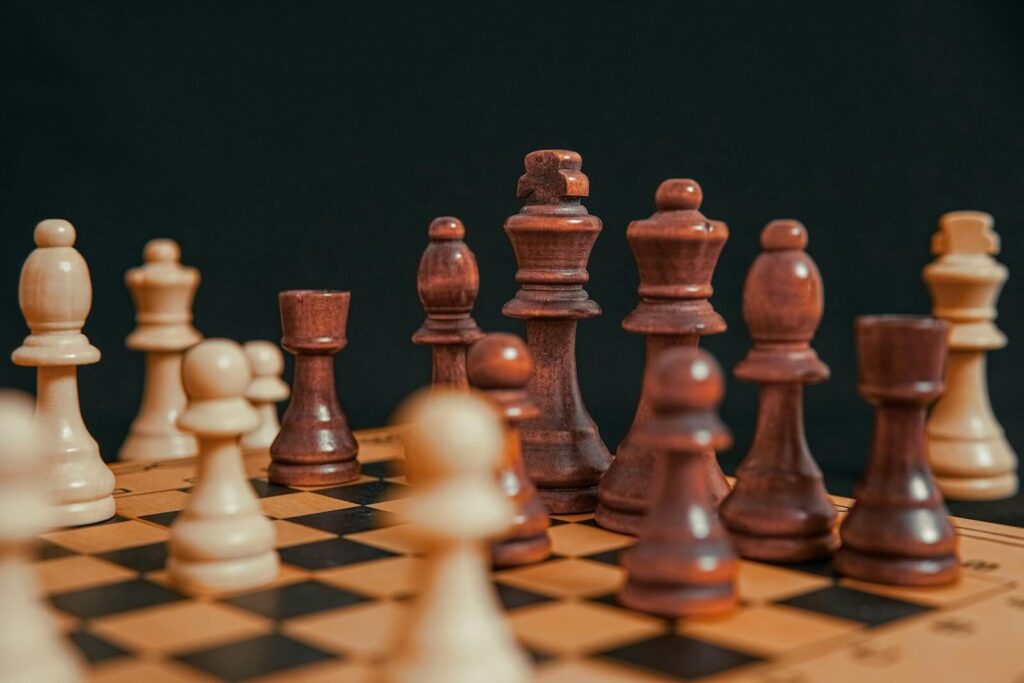 High-angle view of chess pieces on a wooden board, highlighting a strategic game.