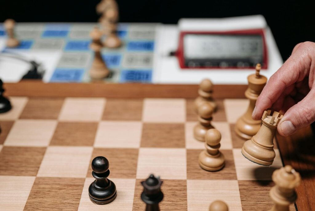 Close-up of a hand moving a chess piece during an intense, focused game.